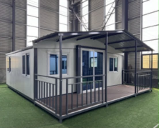 Maison complète avec terrasse couverte, terminée dans le hall de l'atelier avant son chargement — photo réelle
